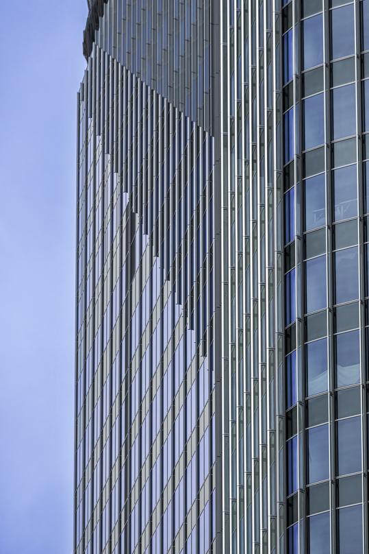 Close-up of the Takanawa Gateway City skyscraper's glass and metal facade, showcasing its modern architectural design.