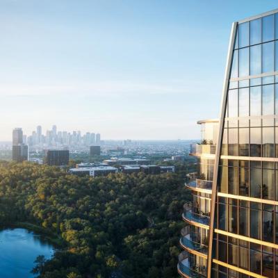 Luxury high-rise St. Regis Residences in Houston with curved glass balconies, overlooking a lush green landscape and city skyline in the background.